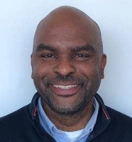 A person smiling for the camera AI-generated content may be incorrect.