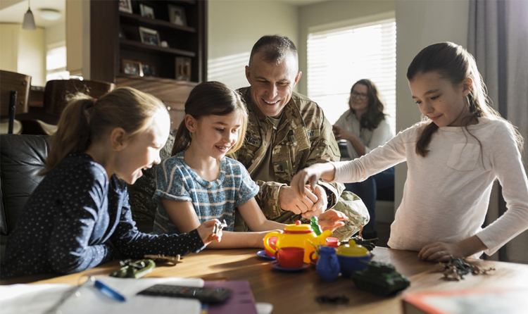 Soldado veterano brincando com suas filhas em casa
