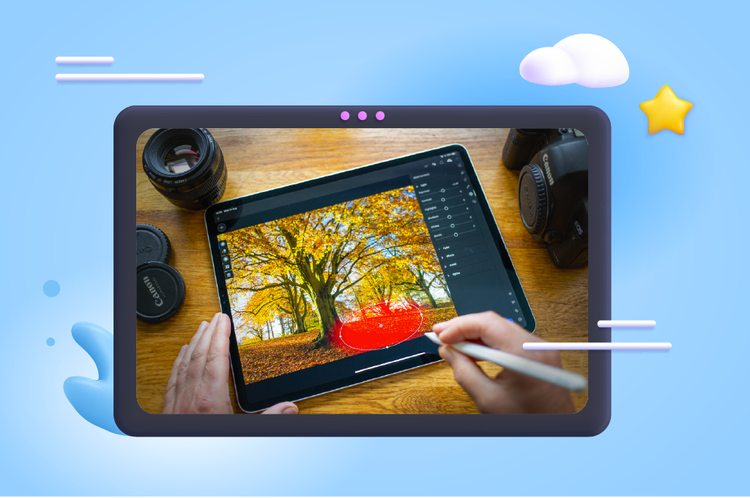 Fotografia de uma mesa com um tablet que tem o lightroom aberto com uma foto de uma árvore e uma mão com caneta digital selecionando uma parte da foto