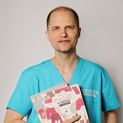 A person in blue scrubs holding books Description automatically generated