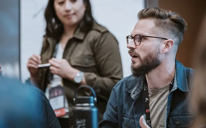 Candid photo of an Adobe staff member consulting attendees at the UX Leader's Summit at Max 2018.