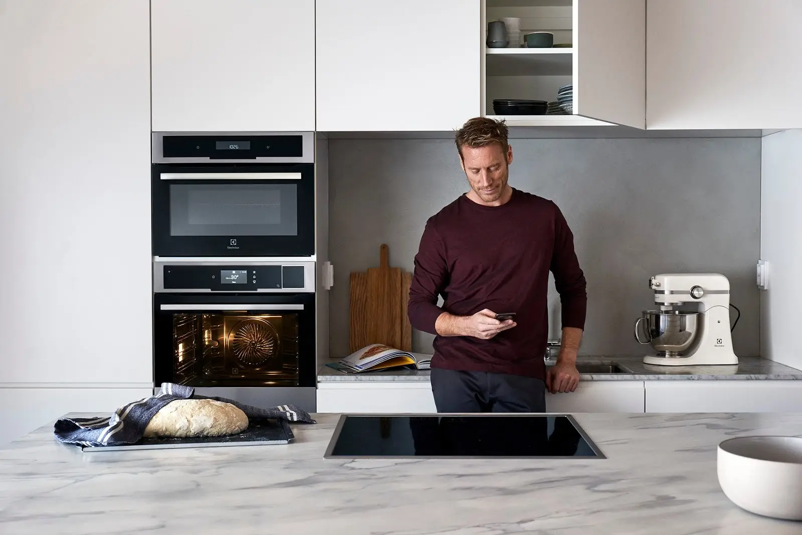 A male model browses their phone in a kitchen appliance photoshoot for Electrolux.