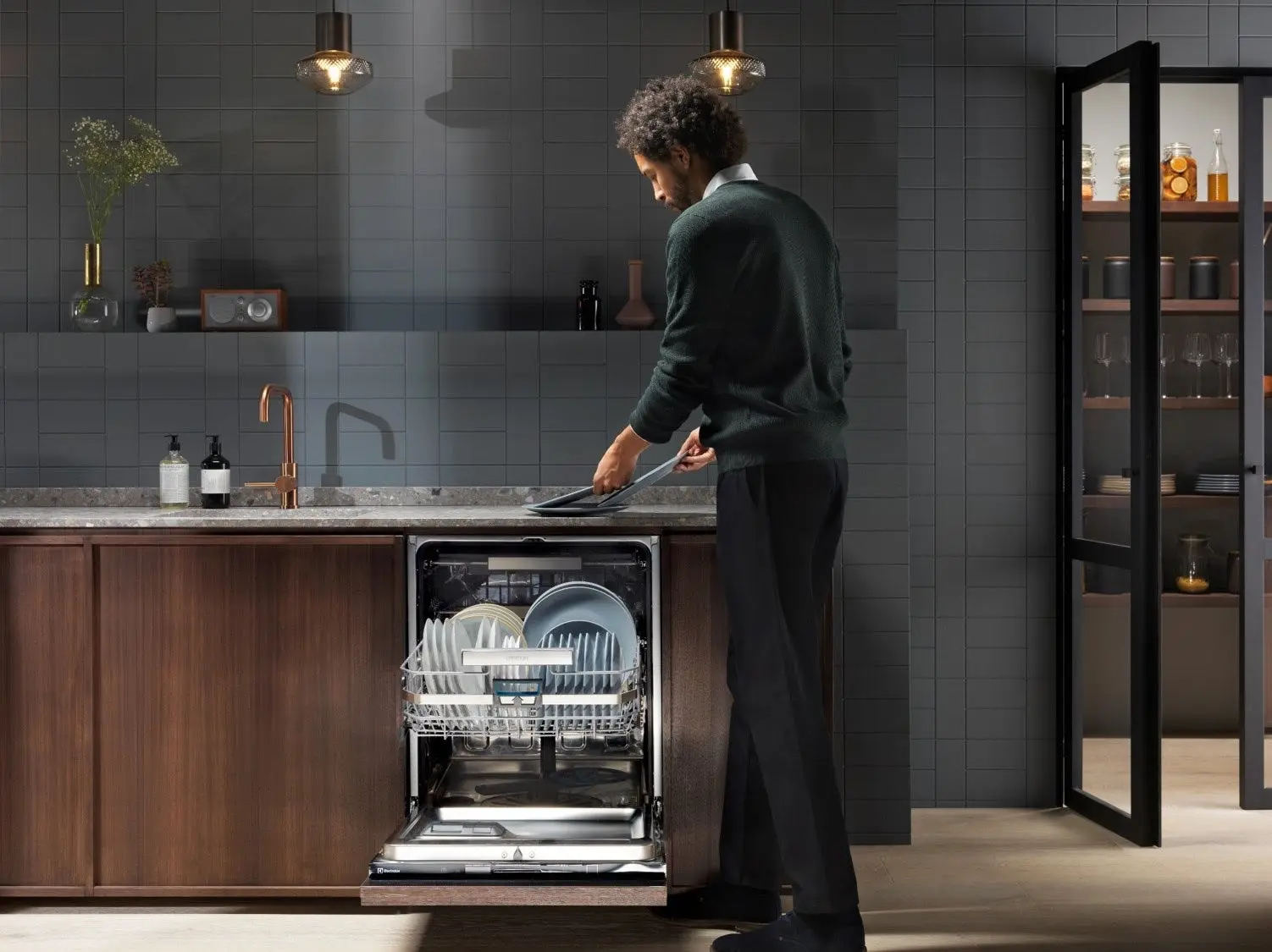 A model poses with an Electrolux dishwasher equipped with sustainability features.