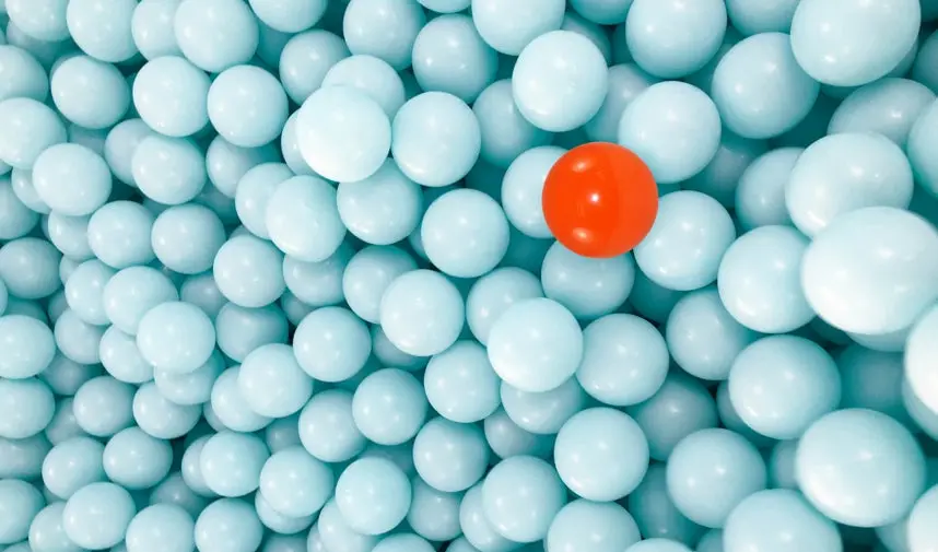 A group of round blue objects with one red ball in the middle