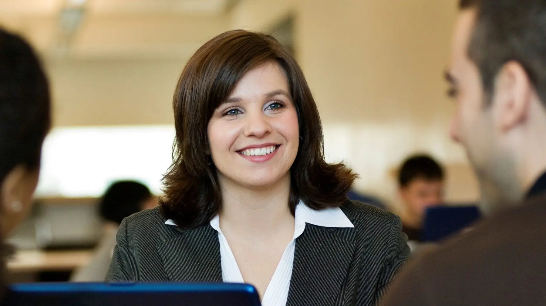 A woman in business attire smiles.