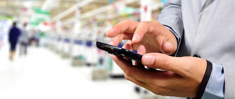 Business Man using mobile phone while shopping in supermarket.