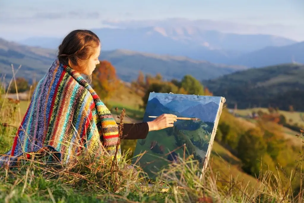 Young artist painting an autumn landscape