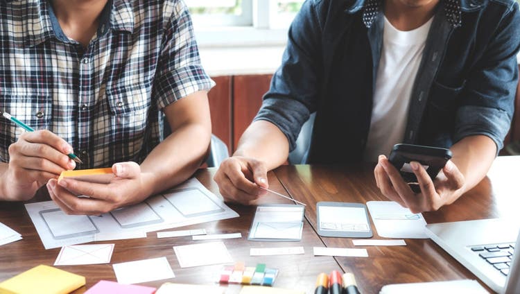 Two people working at a desk.