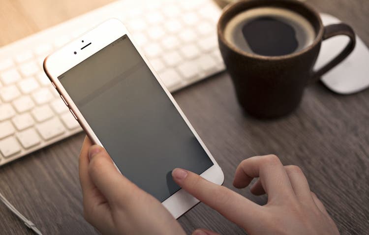 Closeup photo of an iPhone in a person's hand.