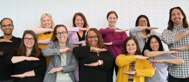 Adobe employees striking the #EachForEqual pose for International Women's Day.
