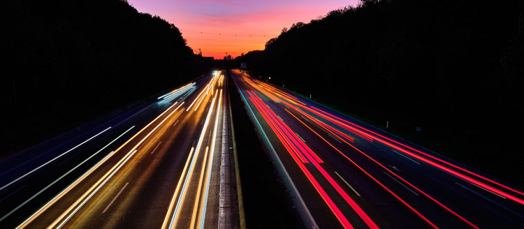 Fast cars driving with a sunset in the background.