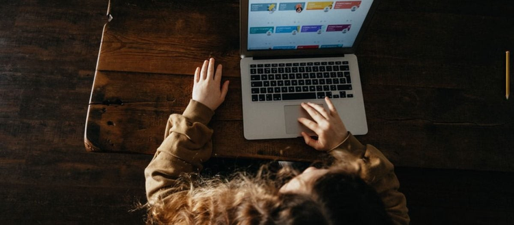 School-aged girl doing homework on a computer.