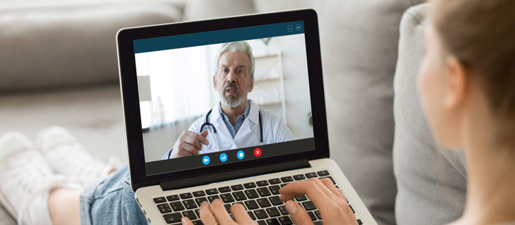 Young woman sit on couch at home have video call with doctor use wireless internet connection.