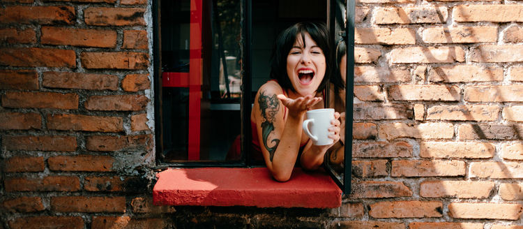 Woman looking out window smiling.