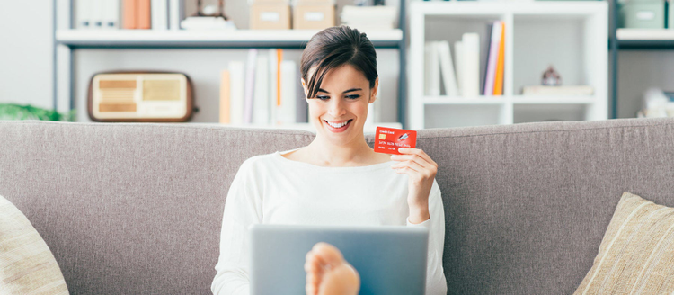 Young smiling woman shopping online using a credit card