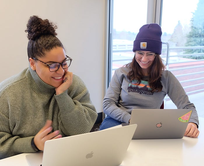 Avery Hutcherson (left) laughs with a colleague (right) in the ProKarma offices.