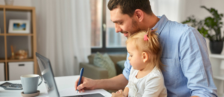 working father with baby daughter and laptop computer at home office