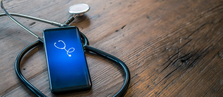 Mobile phone with healthcare app on wood table with stethoscope