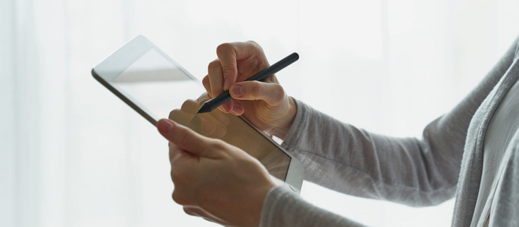 Woman holding tablet and writing on it, person with device side view closup