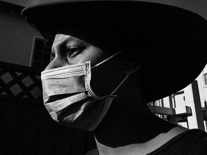 Black man wearing mask and hat.