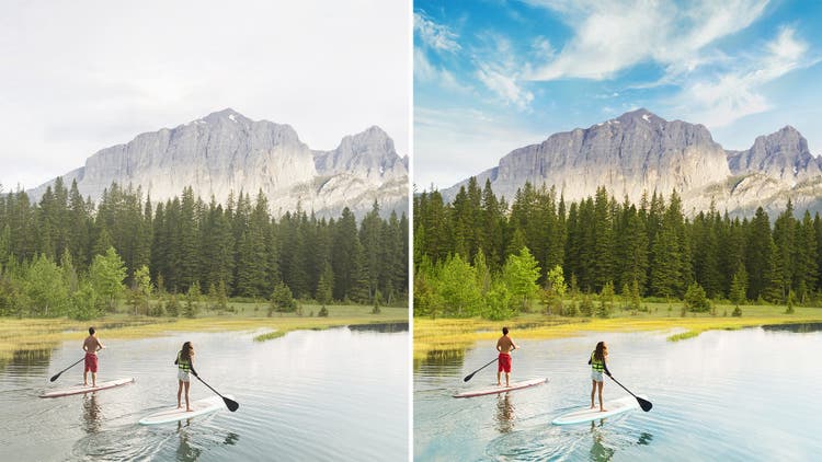 two people paddle boarding on a lake with mountains in the distance