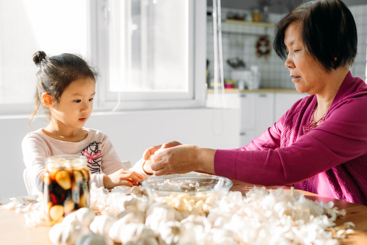 Older woman and younger child at kitchen table making food