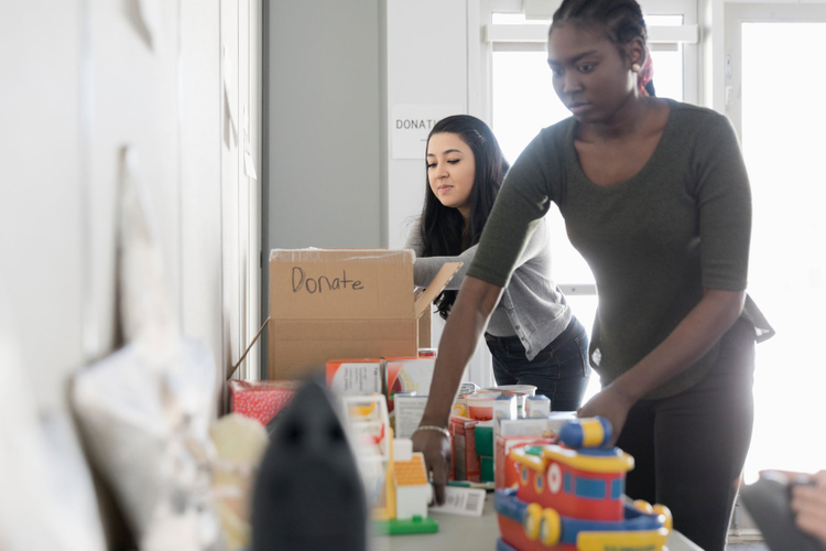 Two young women packing gifts for donation