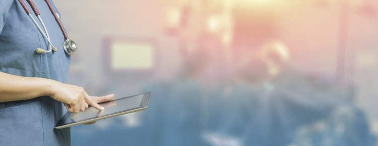 Healthcare worker on tablet.