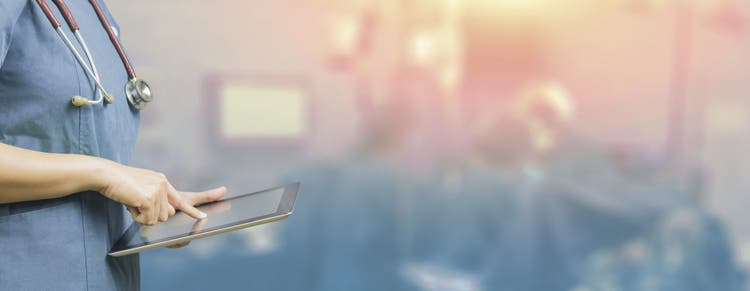 Healthcare worker on tablet.