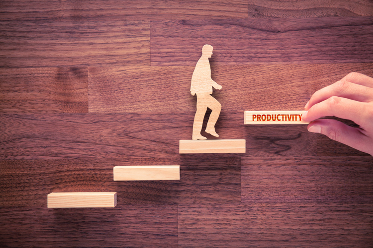 Wooden figure climbing wooden blocks to reach productivity block. 