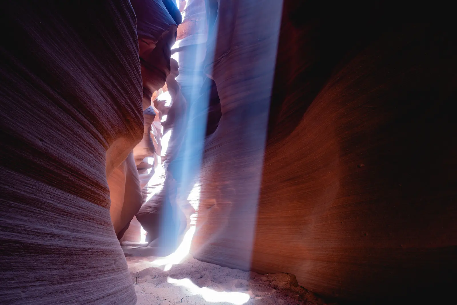 Beam of light coming into the narrow walls of a rock canyon.