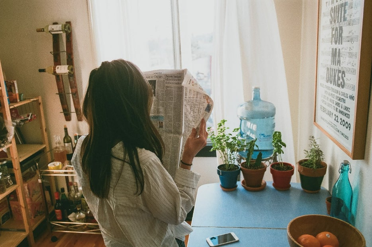 Image of woman reading newspaper.