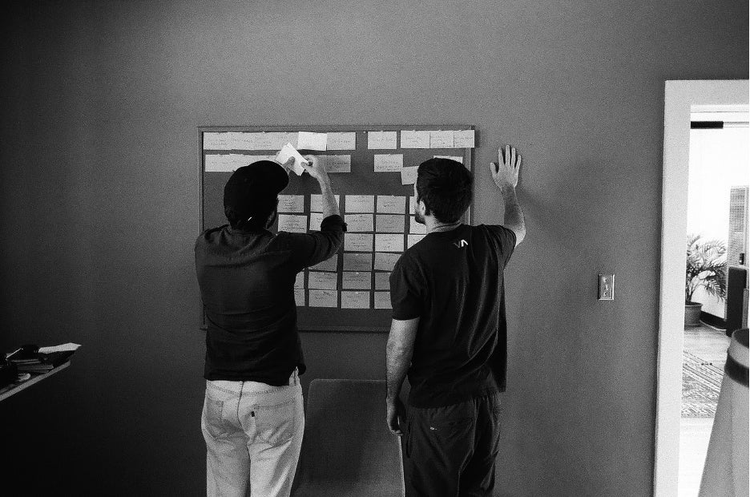 Black and white image of 2 men working in an office.