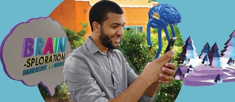 Photo of a man holding his phone with 3D renderings around him.