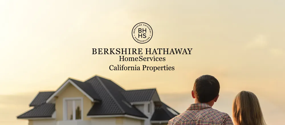 Berkshire Hathaway Home Servies California Properties. A couple looking at a yellow house.