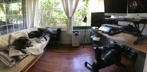 Photo of a room with a couch and a desk with video editing equipment.