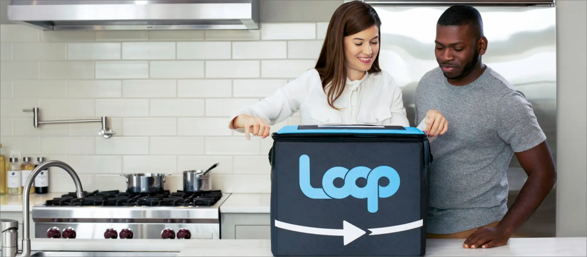 Two people open a box that says Loop on it. 