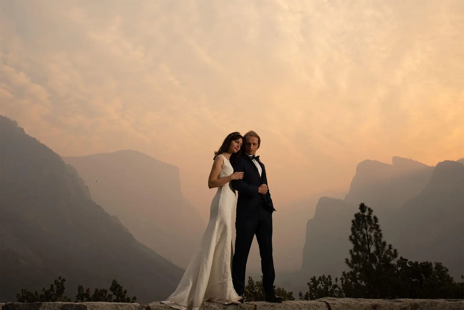Bride and Groom standing in front of mountains. 