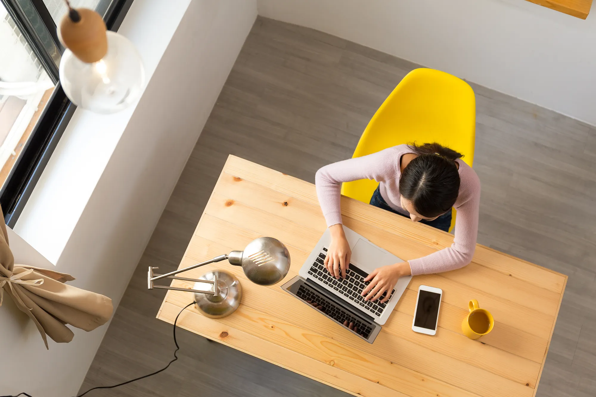Aerial photo of woman typing on her laptop in office
