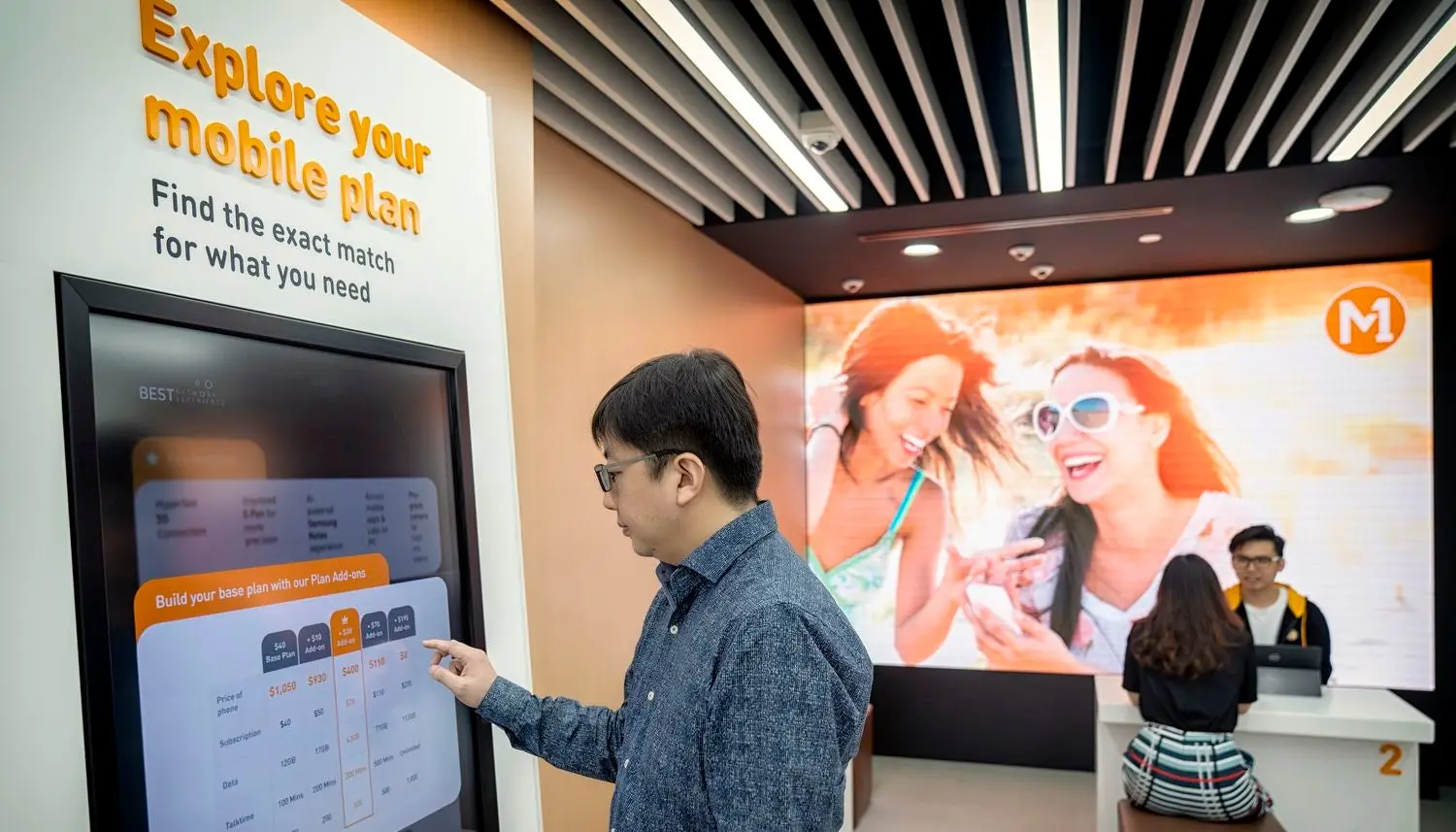 A customer using a touchscreen at the M1 store. 