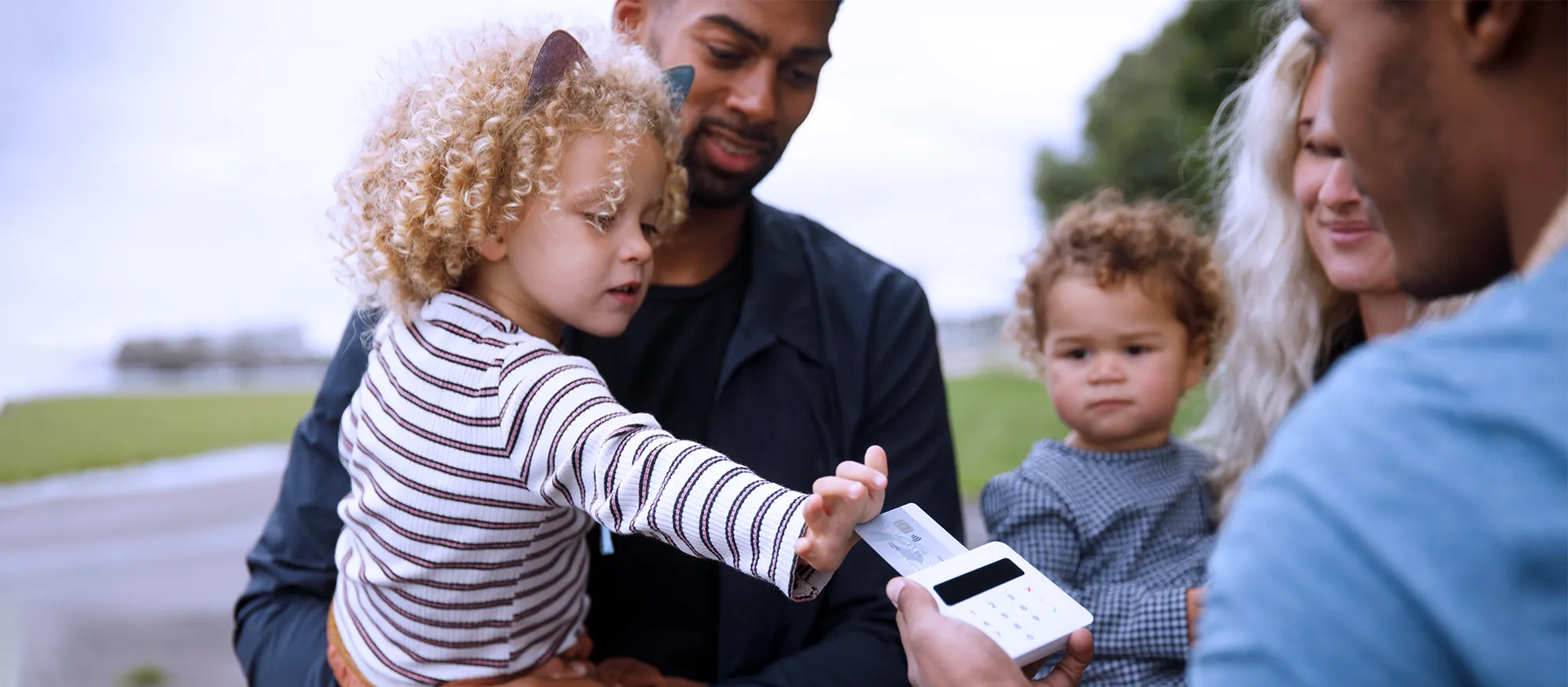 Photograph of a small child pushing a bank card into a payment machine.
