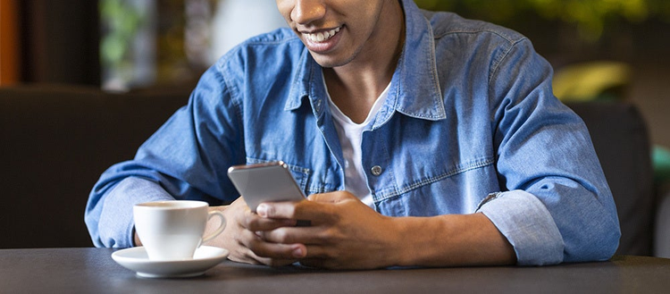 A person interacts with their phone at a coffee shop.