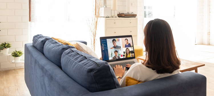 Woman sitting on couch looking at her laptop. 