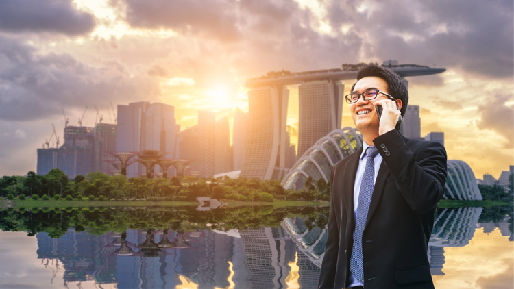 Man on a phone with the skyline of Singapore in the backgroung. 