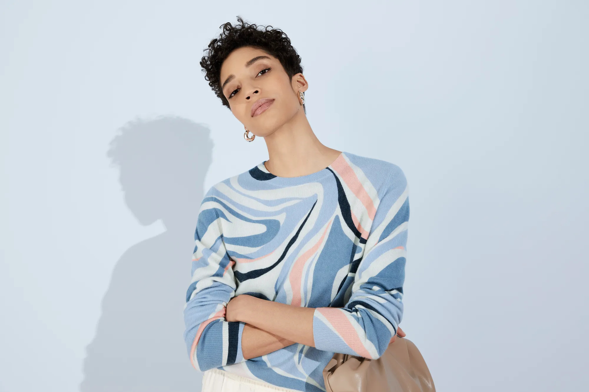 Woman in blue patterned top with arms crossed