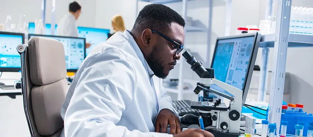 Professional African-American scientist is working on a vaccine in a modern scientific research laboratory. Genetic engineer workplace.