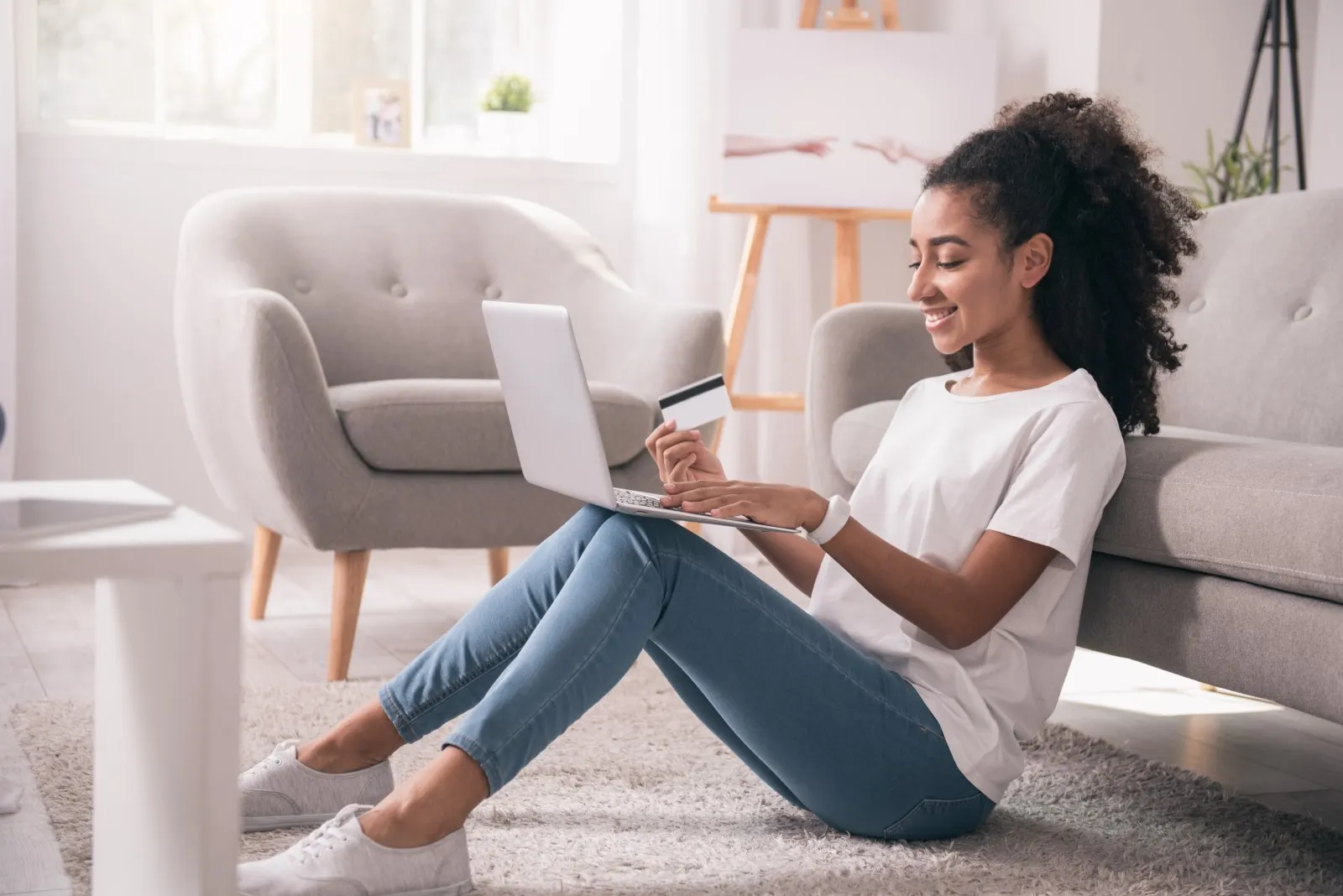 Women looking at laptop while holding her credit card.