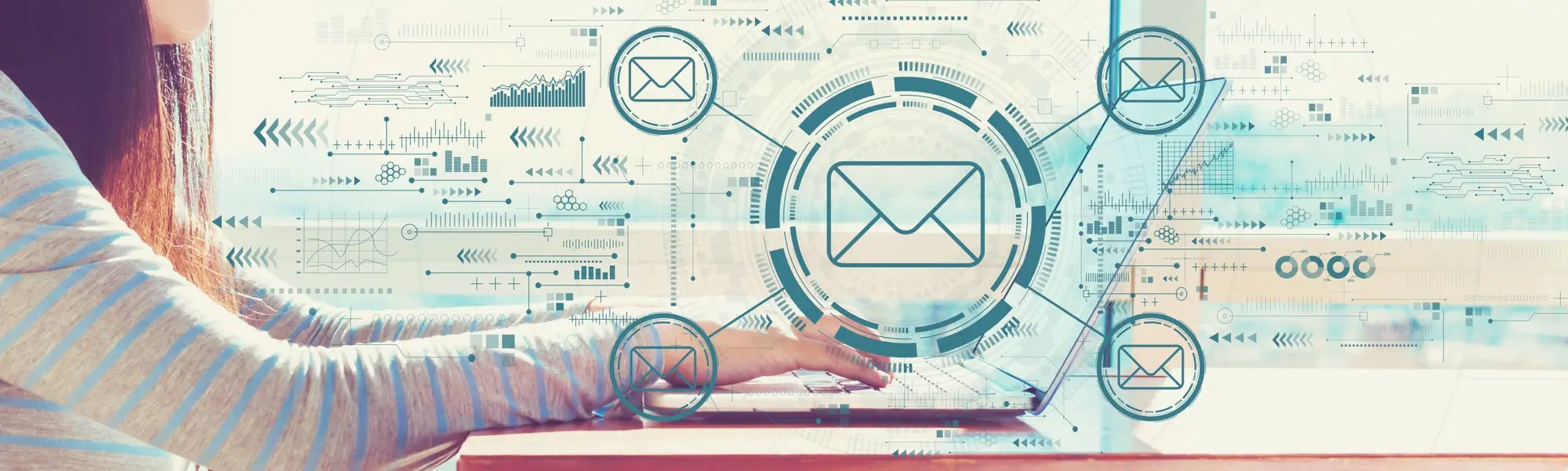 Email concept with woman working on a laptop in brightly lit room.