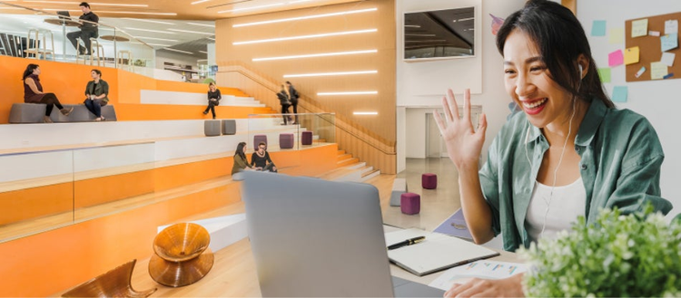 Woman waving at laptop screen