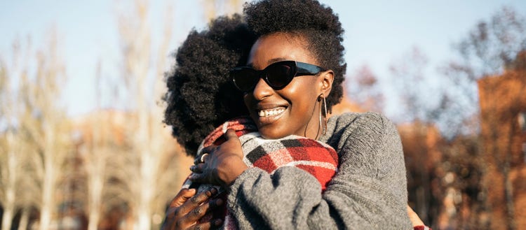 Image of two people smiling and embracing.